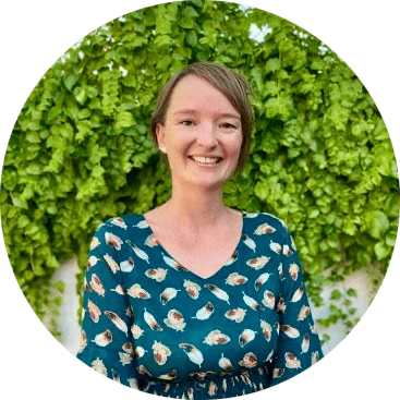 Sjoukje, Operations Manager, in front of a beautiful wall covered in ivy.