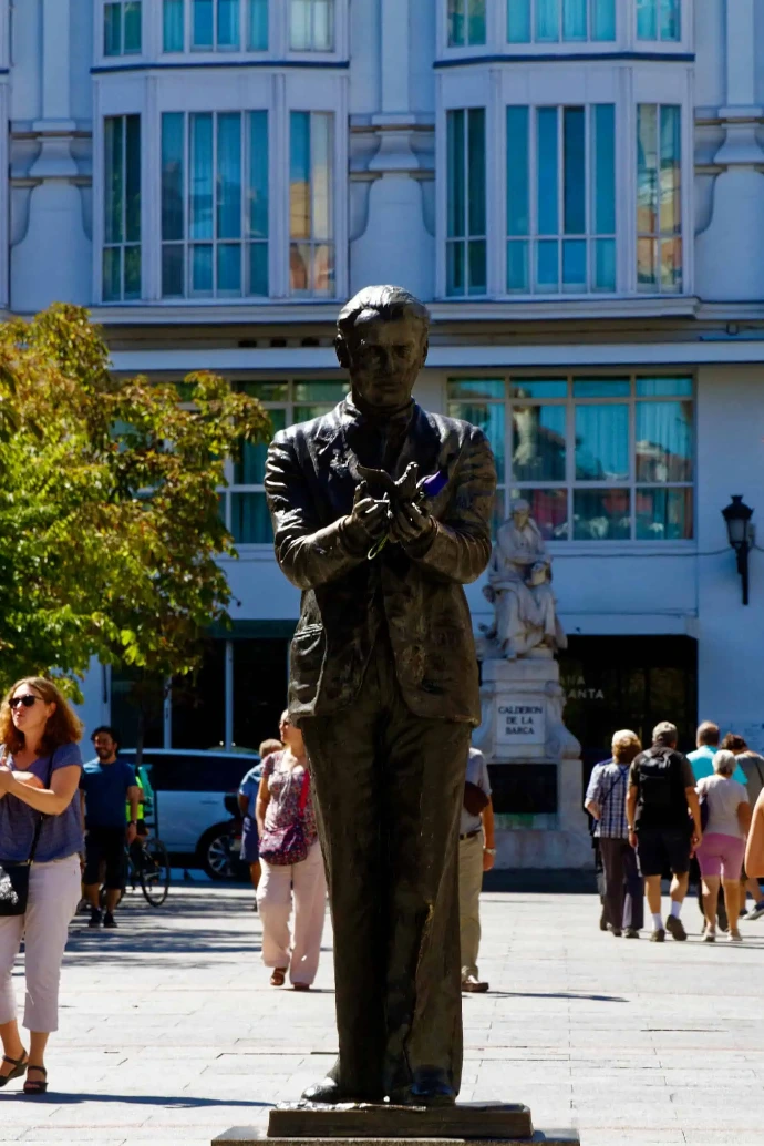 Visitors enjoying the cultural atmosphere in Barrio de las Letras near the statue of poet Federico García Lorca.